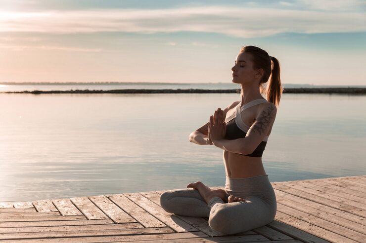 Person practicing meditation in nature surrounded by tranquil forest